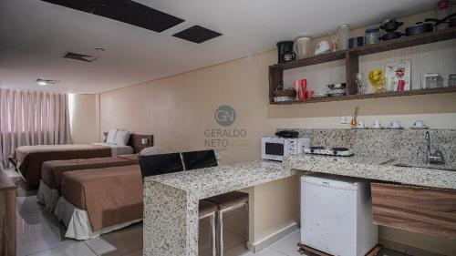 a hotel room with a kitchen and a living room at Sol, mar e vida noturna in João Pessoa