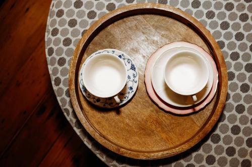two cups on a wooden plate on a table at The Wimberley - Stay in the heart of town Goomeri! in Goomeri