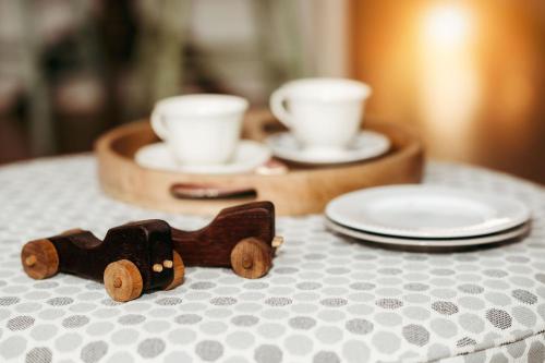a wooden toy car on a table with cups and plates at The Wimberley - Stay in the heart of town Goomeri! in Goomeri