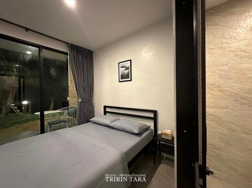 a bedroom with a bed and a large window at ธีริน ธารา - ที่พักริมแม่น้ำแควใหญ่ (TRIRIN TARA) in Ban Tha Pong (1)