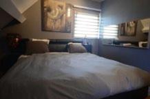 a bedroom with a large bed and a window at B&B le Ravel de Max in Sart-lez-Spa
