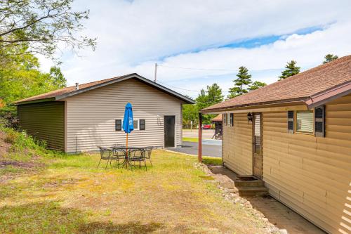 a house with a table and chairs and a blue umbrella at Northwood Tours Escape with Boat Dock Access! in Minocqua