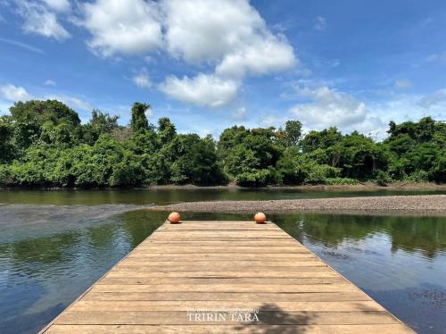a wooden dock in the middle of a river at ธีริน ธารา - ที่พักริมแม่น้ำแควใหญ่ (TRIRIN TARA) in Ban Tha Pong (1)