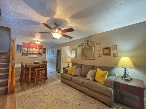 un soggiorno con un divano e un ventilatore a soffitto di Valley Condo 106 - Creekside - WiFi - Hot Tub - Fireplace - Washer - Dryer - Playground a Red River