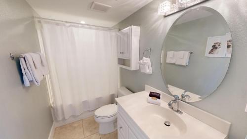 Un baño blanco con lavabo y espejo. en Dolphin Point 105B- by Holiday Isle Properties, en Destin