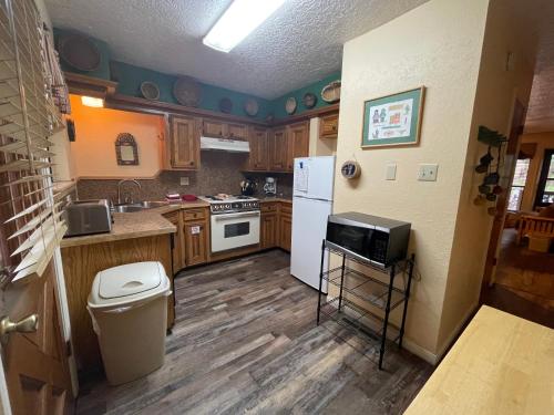 una cucina con pavimenti in legno e frigorifero bianco di Valley Condo 107 - Creekside - WiFi - Hot Tub - Fireplace - Washer - Dryer - Playground a Red River