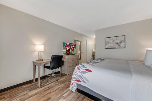 a bedroom with a bed and a desk with a computer at Red Roof Inn & Suites Wilkesboro in Wilkesboro