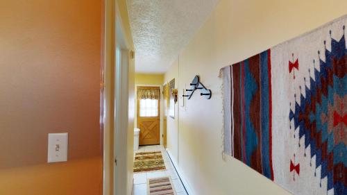 un corridoio con un dipinto sul muro di Valley Condo 110 - Creekside - WiFi - Pet Friendly - Hot Tub - Fireplace - Washer - Dryer - Playground a Red River