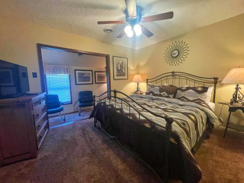 una camera da letto con un letto e un ventilatore a soffitto di Valley Condo 116 - Creekside - WiFi - Hot Tub - Fireplace - Washer - Dryer - Playground a Red River