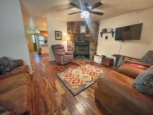 un soggiorno con due divani e un camino di Valley Condo 117 - Creekside - WiFi - Hot Tub - Fireplace - Washer - Dryer - Playground a Red River