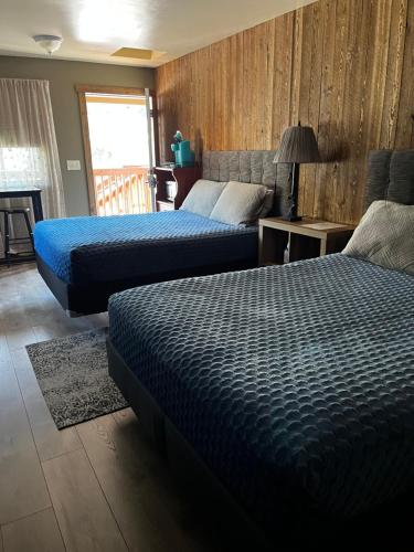 a bedroom with two beds and a table with a lamp at ParkWay Yellowstone Guest House Room #1 in Gardiner