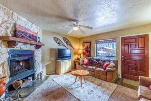 un soggiorno con divano e camino di Valley Condo 119 - Creekside - WiFi - Hot Tub - Fireplace - Washer - Dryer - Playground a Red River