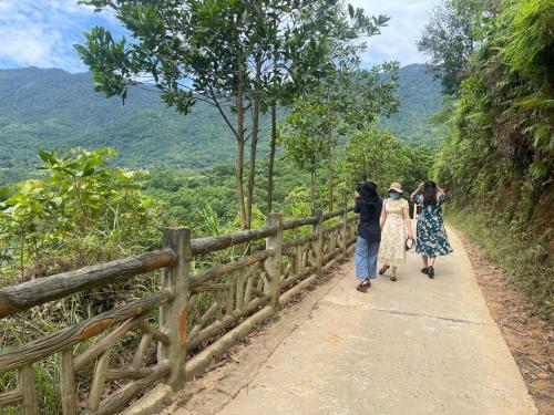 a group of three people walking down a path at Pù Luông Sala Homestay in Hương Bá Thước