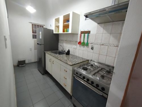 a small kitchen with a stove and a refrigerator at Las Dos Tinajas in La Punta
