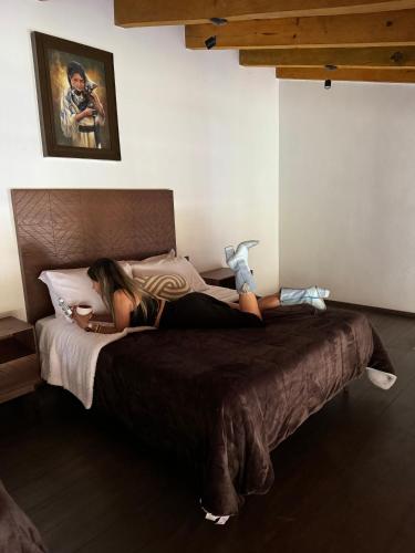 a woman laying on a bed in a bedroom at Cabaña Colorata Residencial in Atemajac de Brizuela