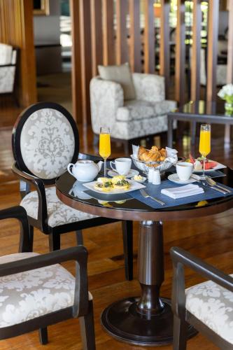 a table with food and drinks on it with two chairs at Dusit Thani Manila in Manila