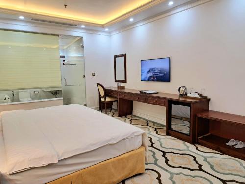 a hotel room with a bed and a desk and a desk at THE SHINE 2 HOTEL & APARTMENT in Ðông Khê