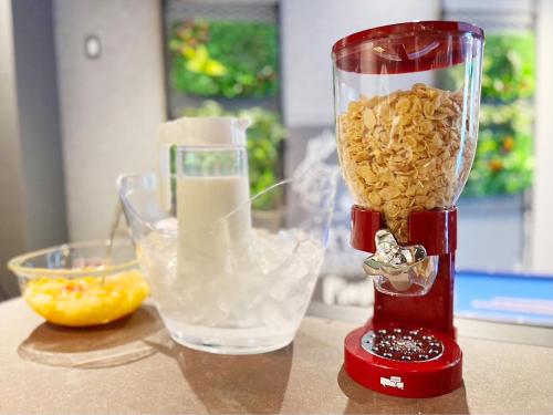 a red blender on a counter with a bowl of food at Hotel SUI Ginza Kyobashi by ABEST in Tokyo