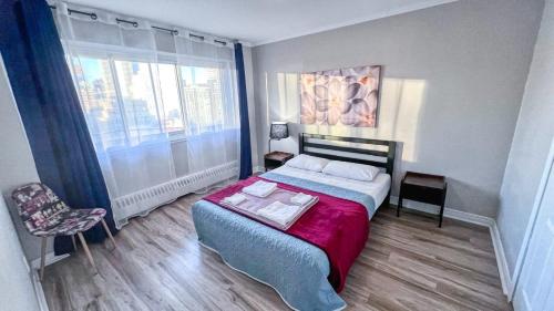 a bedroom with a bed and a large window at Downtown Central Residences in Montréal