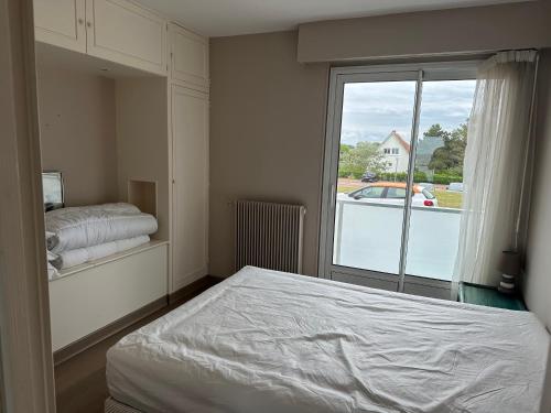 une chambre avec un lit et une grande fenêtre dans l'établissement Appartement Varaville: Face à la mer avec loggia et parking privé, 4 pers. - FR-1-487-306, à Varaville