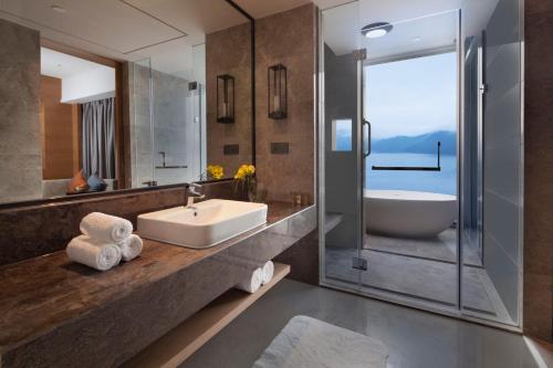 a bathroom with a sink and a shower and a tub at Crowne Plaza Hangzhou Thousand Island Lake by IHG in Thousand Island Lake