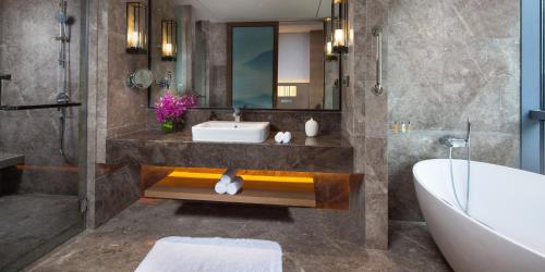 a bathroom with a sink and a tub and a bath tub at Crowne Plaza Hangzhou Thousand Island Lake by IHG in Thousand Island Lake