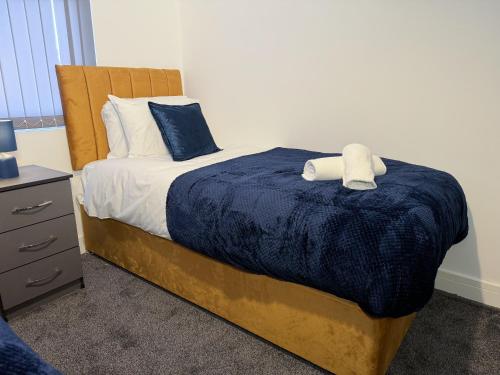 a bedroom with a bed with a blue blanket at The Groves Lodge Ensuite Rooms In Stockton in Stockton-on-Tees