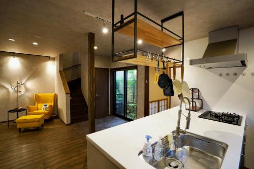 a kitchen with a sink and a yellow chair at 清楓Inn in Kyoto