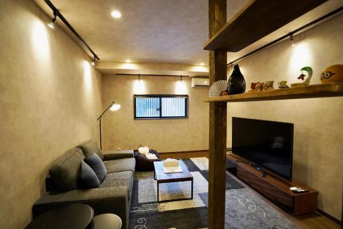 a living room with a couch and a flat screen tv at 清楓Inn in Kyoto