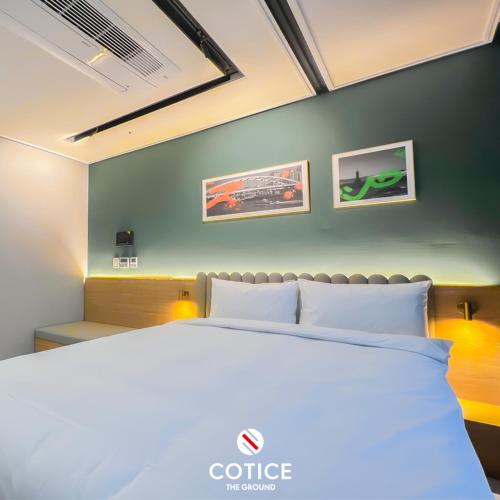 a bedroom with a white bed and two pictures on the wall at Cotice The Bridge in Busan