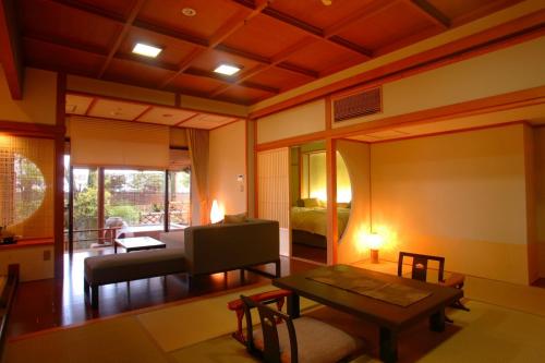 a living room with a couch and a table at Grandia Housen in Awara