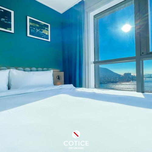 a bedroom with a white bed and a window at Cotice The Bridge in Busan
