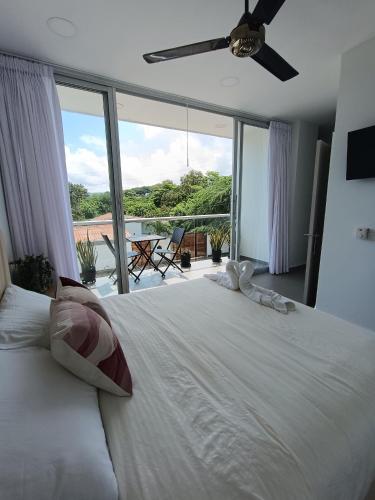 a bedroom with a large white bed and a large window at Hotel Aqua House in Tubará
