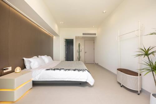 a bedroom with a large white bed and a desk at Sanya Sun Seaview Apartment in Sanya
