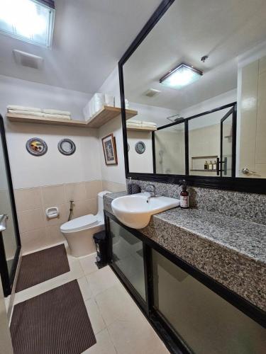 a bathroom with a sink and a toilet at Verdon Parc 2 Bedroom Unit with Big Balcony in Davao City