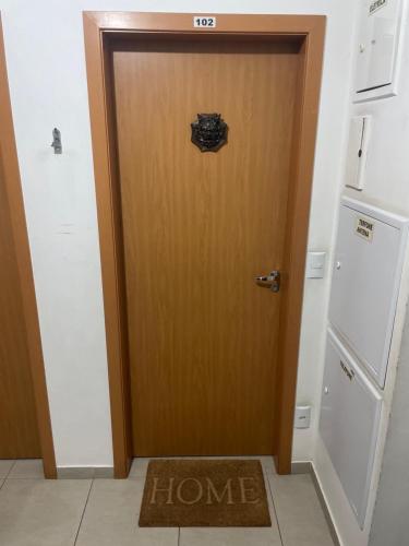a wooden door with a home sign on it at Apartamento térreo de 1 quarto próximo a Arena Opus in São José