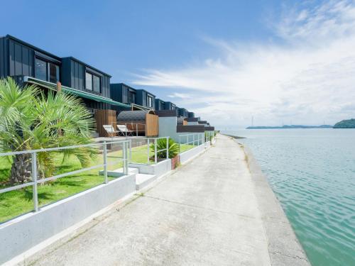 a pathway next to a body of water with houses at Rakuten STAY HOUSE Amakusa 103 in Kami Amakusa