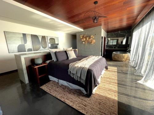a bedroom with a large bed and a wooden ceiling at Nook Bay House in Whangarei