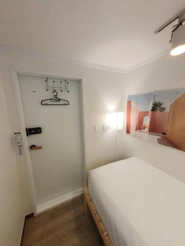 a bedroom with a white bed and a door at OMG house in Seoul