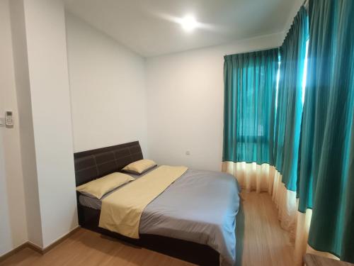 a bedroom with a bed and a window with blue curtains at Homelite Resort in Miri