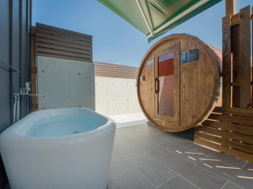 a bathroom with a large tub and a wooden barrel at Rakuten STAY HOUSE Amakusa 104 in Kami Amakusa