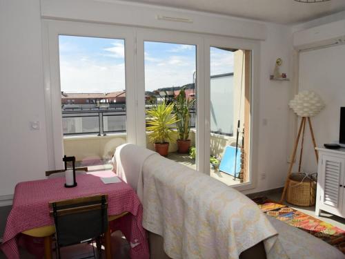 Cette chambre dispose d'une table et offre une vue sur un balcon. dans l'établissement Studio Cabine au Lavandou - 4 Pers, Clim, Piscine, Terrasse, Parking, 950m Plage - FR-1-803-26, au Lavandou
