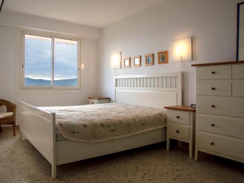 une chambre blanche avec un lit et une fenêtre dans l'établissement Le Lavandou, T2 climatisé pour 4 pers avec parking près de la plage - FR-1-803-28, au Lavandou