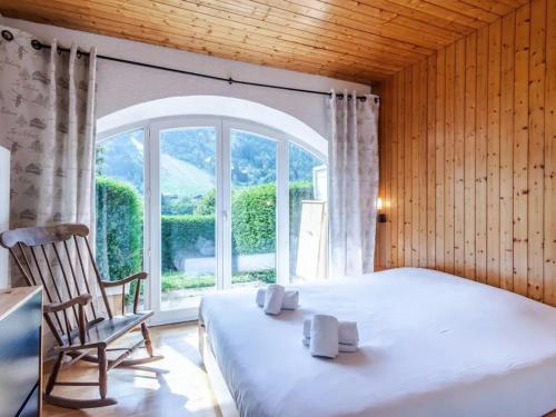 une chambre avec un lit, une chaise et une fenêtre dans l'établissement Charmant T2 rénové avec jardin, parking privé et accès direct aux pistes, proche du centre de Morzine - FR-1-679-12, à Morzine