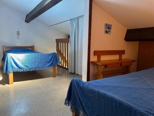 - une chambre avec 2 lits et une table en bois dans l'établissement T2 Mezzanine Saint-Cyprien: Proche Plage, Parking Sécurisé, Équipé, Animaux Acceptés - FR-1-793-6, à Saint-Cyprien