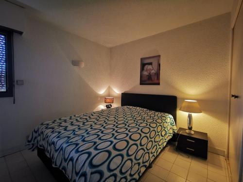 une chambre avec un lit et deux lampes et une fenêtre dans l'établissement T2 au Lavandou pour 4 avec parking, terrasse mer et accès plage - FR-1-803-23, au Lavandou