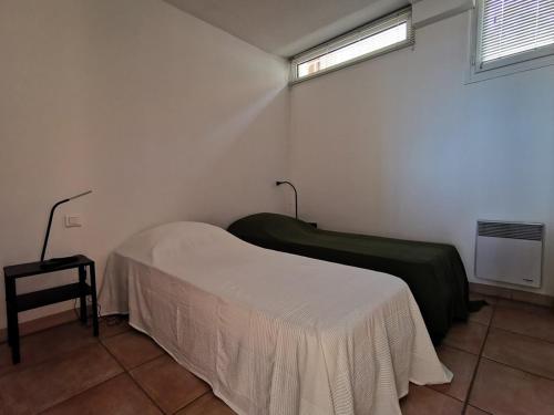- une chambre avec 2 lits dans une chambre avec une fenêtre dans l'établissement Appartement T2 équipé avec terrasse et parking au Lavandou - FR-1-803-25, au Lavandou