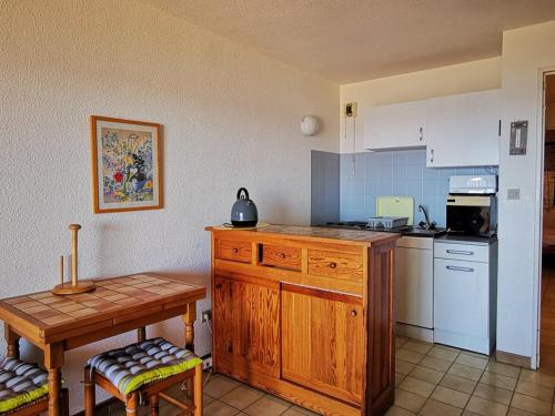 - une cuisine avec un comptoir en bois et une table dans l'établissement Le Lavandou T2 pour 4 personnes avec terrasse, vue mer, parking - FR-1-803-36, au Lavandou
