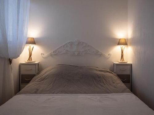 - une chambre avec un lit, 2 tables de chevet et 2 lampes dans l'établissement Location T2 au Lavandou, terrasse, clim, parking, proche plage et centre, 4 couchages - FR-1-803-46, au Lavandou