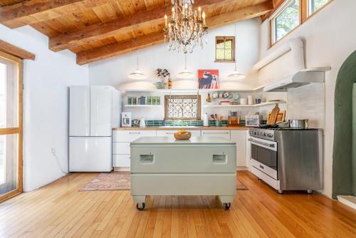a kitchen with white appliances and a wooden floor at Stunning Artful Adobe - Super Walkable Location - Cozy and Comfortable in Santa Fe